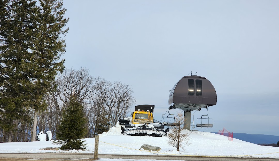 A ski lift ascends the snowy slopes of Laurel Mountain a popular ski resort in Boswell Pennsylvania. Visible winter sports activities hint at the vibrant scene at this winter sports center.