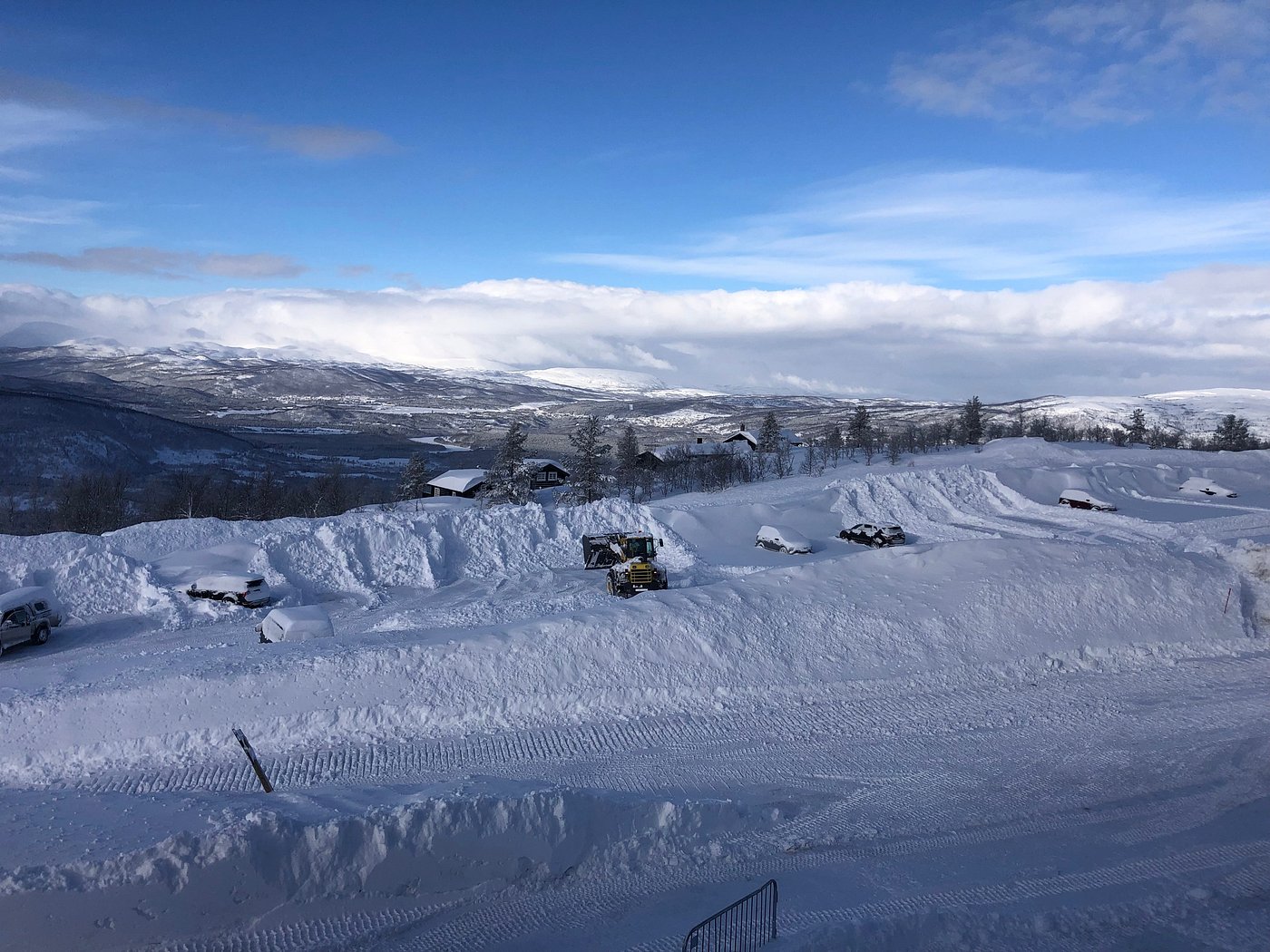 A winter sports scene at Målselv Fjellandsby in Moen, Troms, Norway featuring a ski resort and chalet nestled within a stunning, snow-covered landscape.