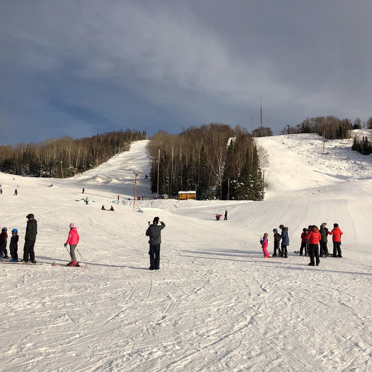Mt Baldy Thunder Bay in Canada - a group of people skiing down a snow covered hill.