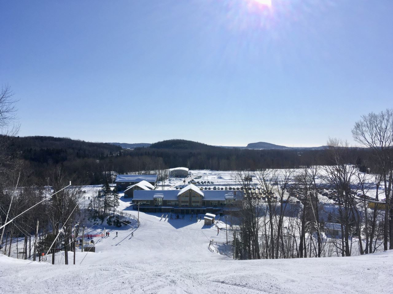 Scenic view of Vallée du Parc a bustling ski resort in Shawinigan Quebec under a bright sunny sky. Winter sports enthusiasts enjoy the pristine snow-covered slopes amidst beautiful winter scenery.