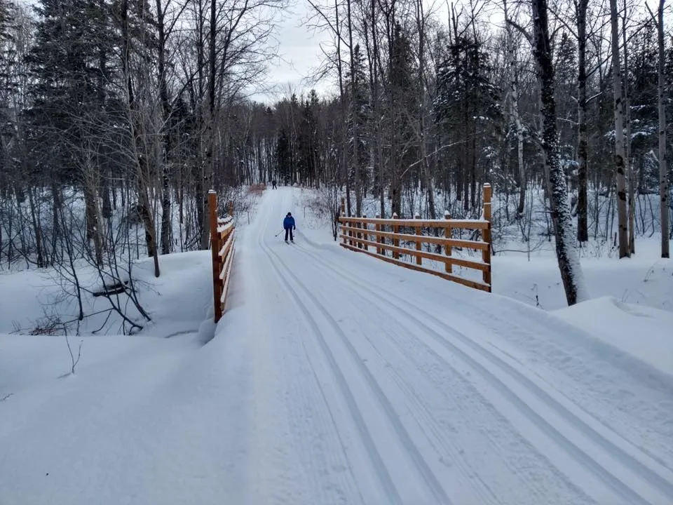 Vallée du Parc in Canada - a person walking across a bridge in the snow.