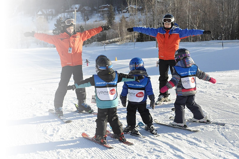 A family enjoying a day of skiing at the Vallée du Parc winter sports centre in Shawinigan Quebec. Snow-covered slopes and an ensemble of skiers enhance the lively winter scene.