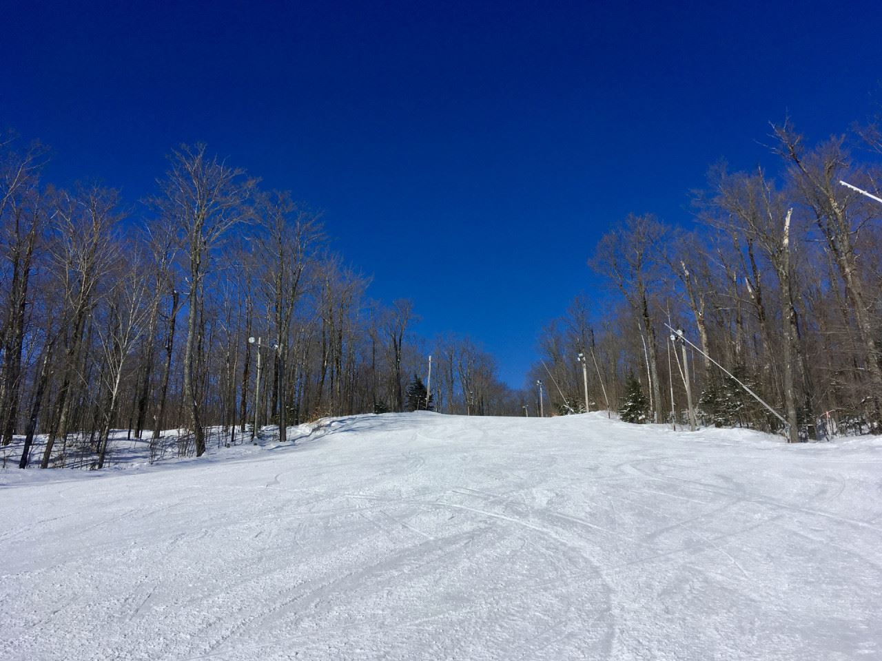 Winter scene at Vallée du Parc in Quebec, Canada featuring skilled skier in action amidst a bustling ski resort, with ski lifts operating in the background.