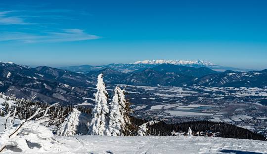 Scenic view of a winter sports scene at Martinské Hole, a bustling ski resort in Martin, Žilina, Slovakia. Stunning winter scenery featuring a mountain backdrop.