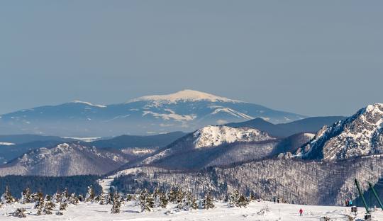 Winter sports enthusiasts enjoying a day at the ski resort in Martinské Hole, Slovakia, surrounded by the stunning scenic view of snow-covered mountains.