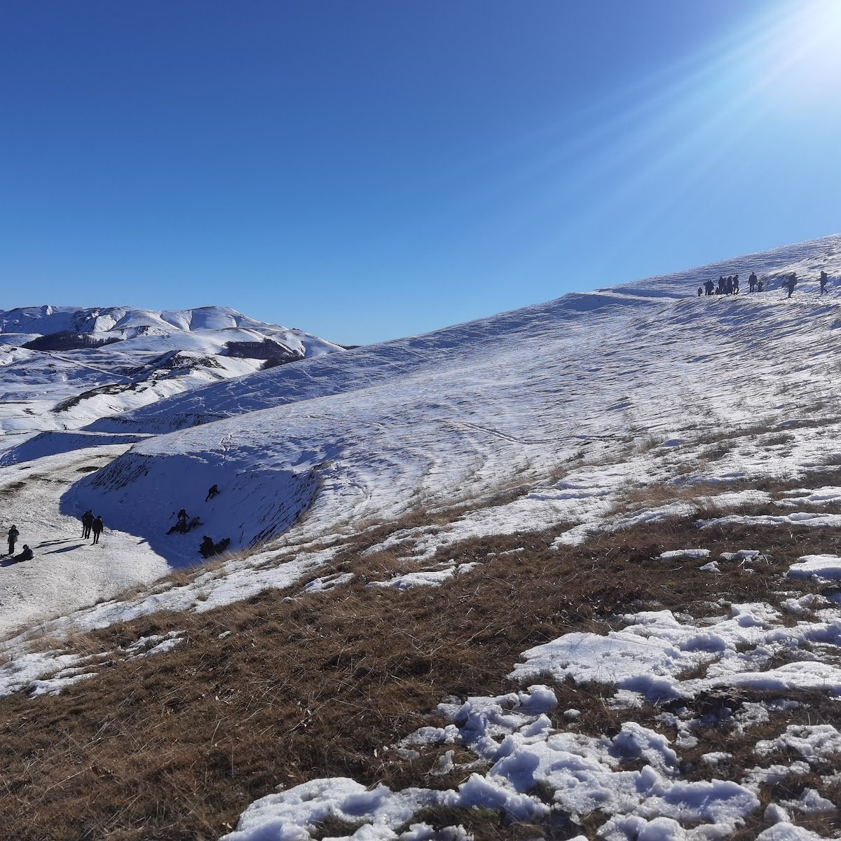 Velouchi Snow Centre S.A. in Greece - a group of people walking up a snow covered mountain.