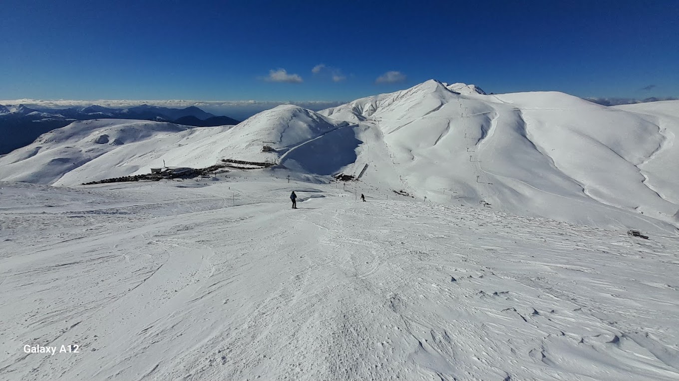 Velouchi Snow Centre S.A. in Greece - a person standing on top of a snowy mountain.