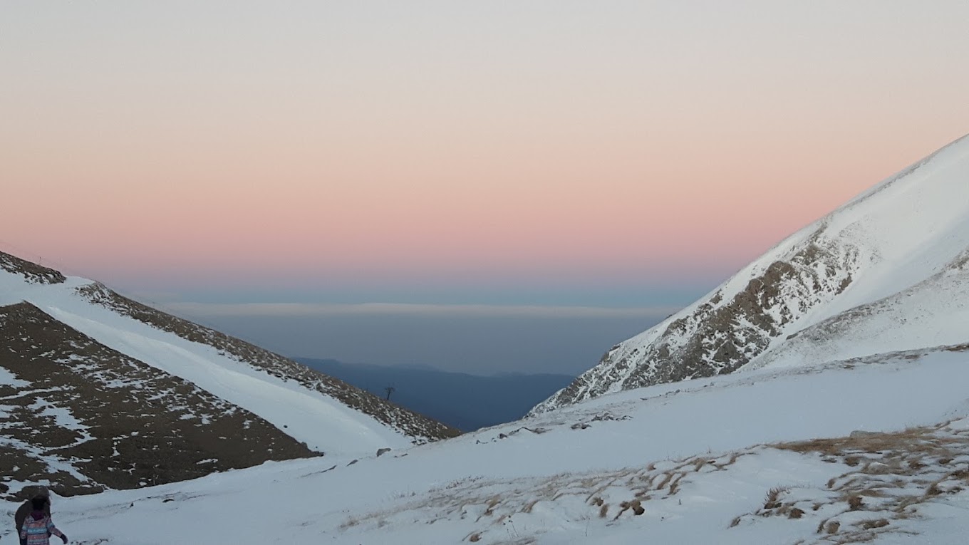 Velouchi Snow Centre S.A. in Greece - a person standing on top of a snow covered mountain.