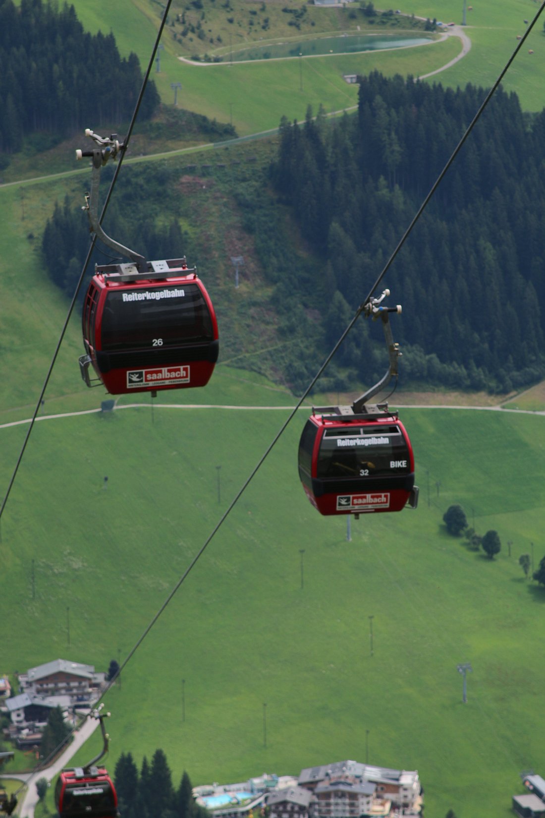 A ski lift ascending the slopes of the Reitherkogelbahn in Austria's Tyrolian Alps, with a small chalet and the expanse of the ski resort seen in the background.