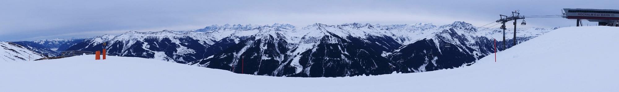 Winter scene at Reitherkogelbahn in Tyrol, Austria featuring a snow-covered mountain, a typical Austrian chalet, and various activities at a bustling ski resort.