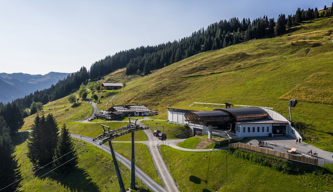 Ski resort at Reitherkogelbahn in Tyrol, Austria, featuring a ski lift ascending up the snowy mountain. Scene also includes a charming chalet, making it a perfect winter sports destination.