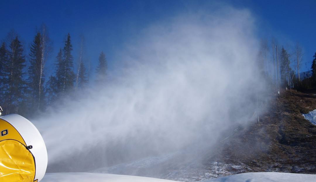 Skier navigating a slope at Himos ski resort in Jämsä West Finland amidst a beautiful winter scenery with a ski lift in the backdrop.