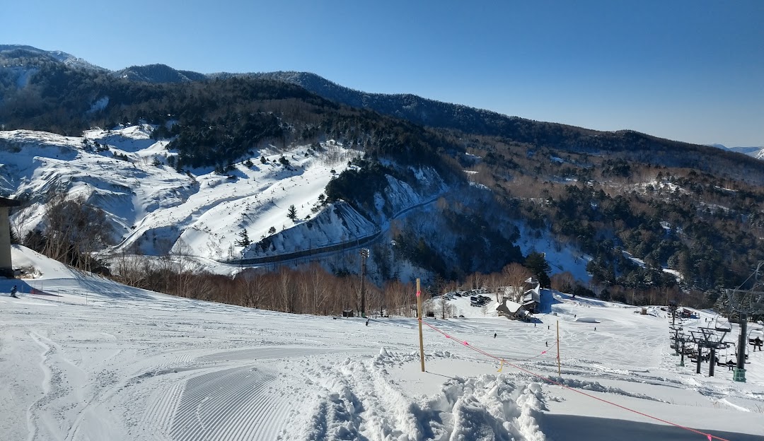 Winter sports enthusiasts enjoy the day at Manza Onsen in Japan's Gunma, featuring a picturesque challet, part of the ski resort complex, set in stunning winter scenery.