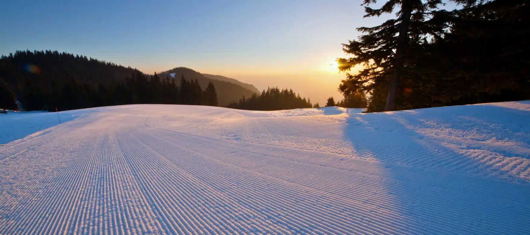 A skier enjoying a winter sports scene at Golte Ski Resort in Rečica ob Savinji, Slovenia. The pristine white snowscape under the clear blue sky provides a stunning winter scenery.