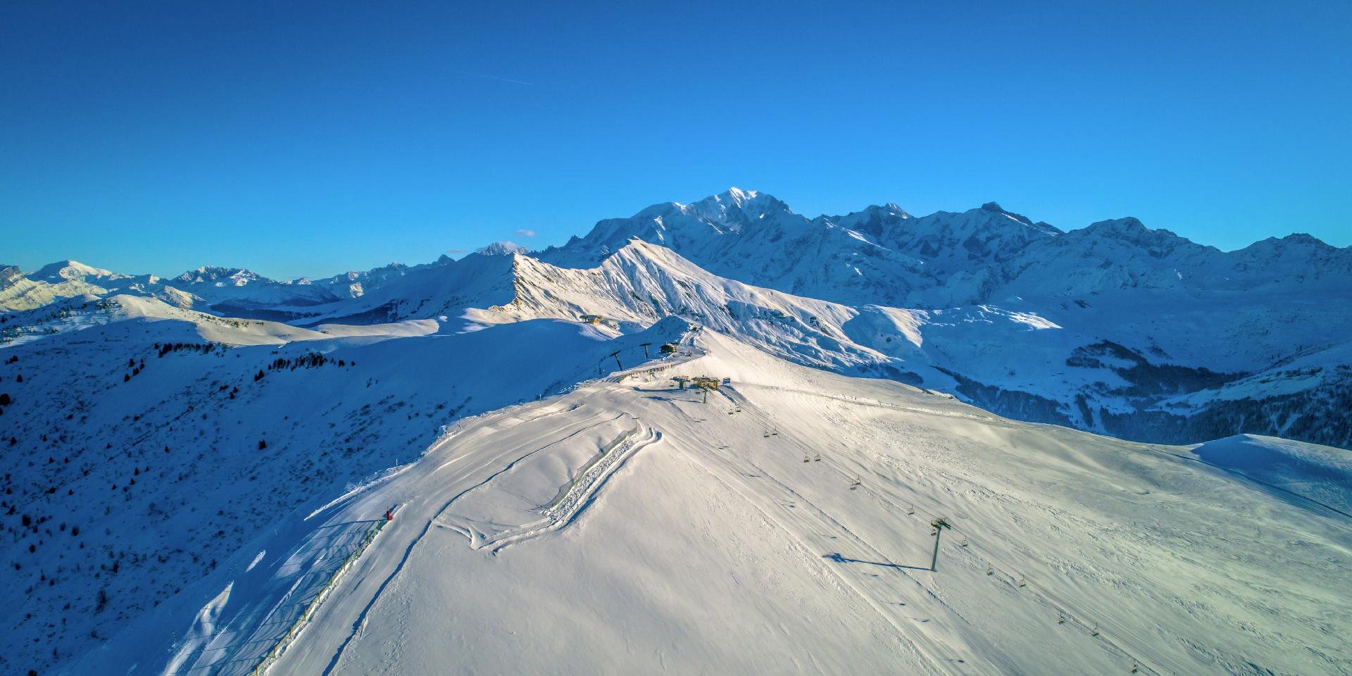Espace Diamant – Les Saisies | ​Notre-Dame-de-Bellecombe | ​Praz sur Arly | ​Flumet | ​Crest-Voland in France - a clear blue sky.