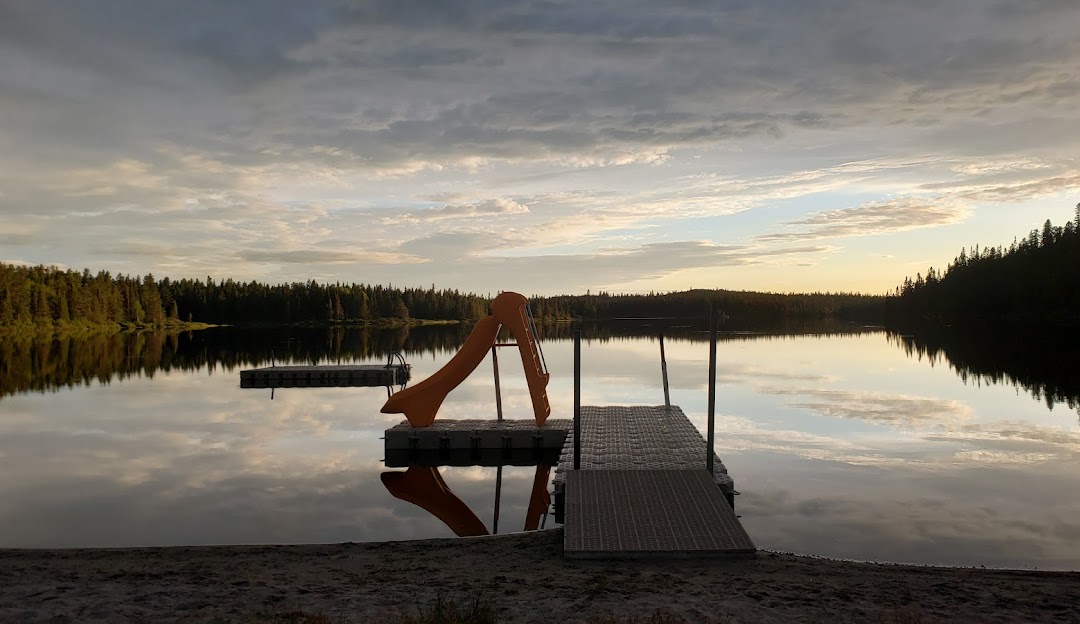 View of Mont-Vidéo Quebec featuring a serene lake with a quaint chalet nestled nearby under the bright sun of a beautiful day.
