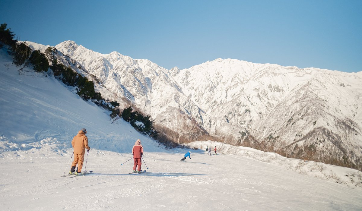 Blue Resort Yanaba in Japan - a group of people skiing down a snowy slope.