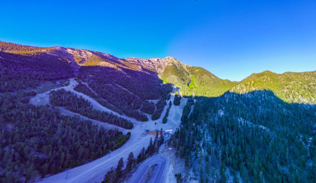Ski enthusiasts enjoying the slopes at Las Vegas Ski and Snowboard Resort – Lee Canyon in the heart of Nevada, surrounded by snow-capped mountains and a moving ski lift.