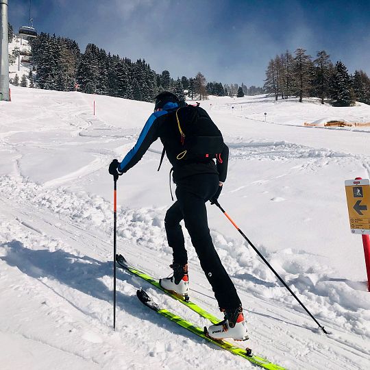 A skier dominating a snowy slope in Tyrol, Austria, savoring winter sports amidst an enchanting chalet backdrop. Nearby, a young novice fine-tunes their skills in the snow, surrounded by a skiing family.
