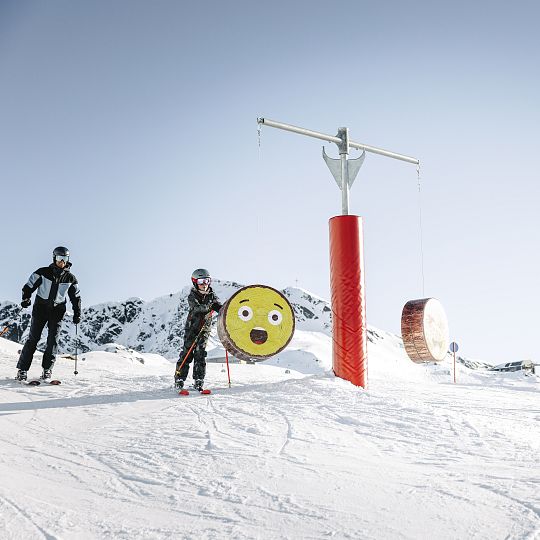 A skier navigates the slopes at Hochzeiger-Jerzens resort in Tyrol Austria surrounded by pristine white snow. A ski lift ascends the mountain in the background part of the bustling winter sports scene.