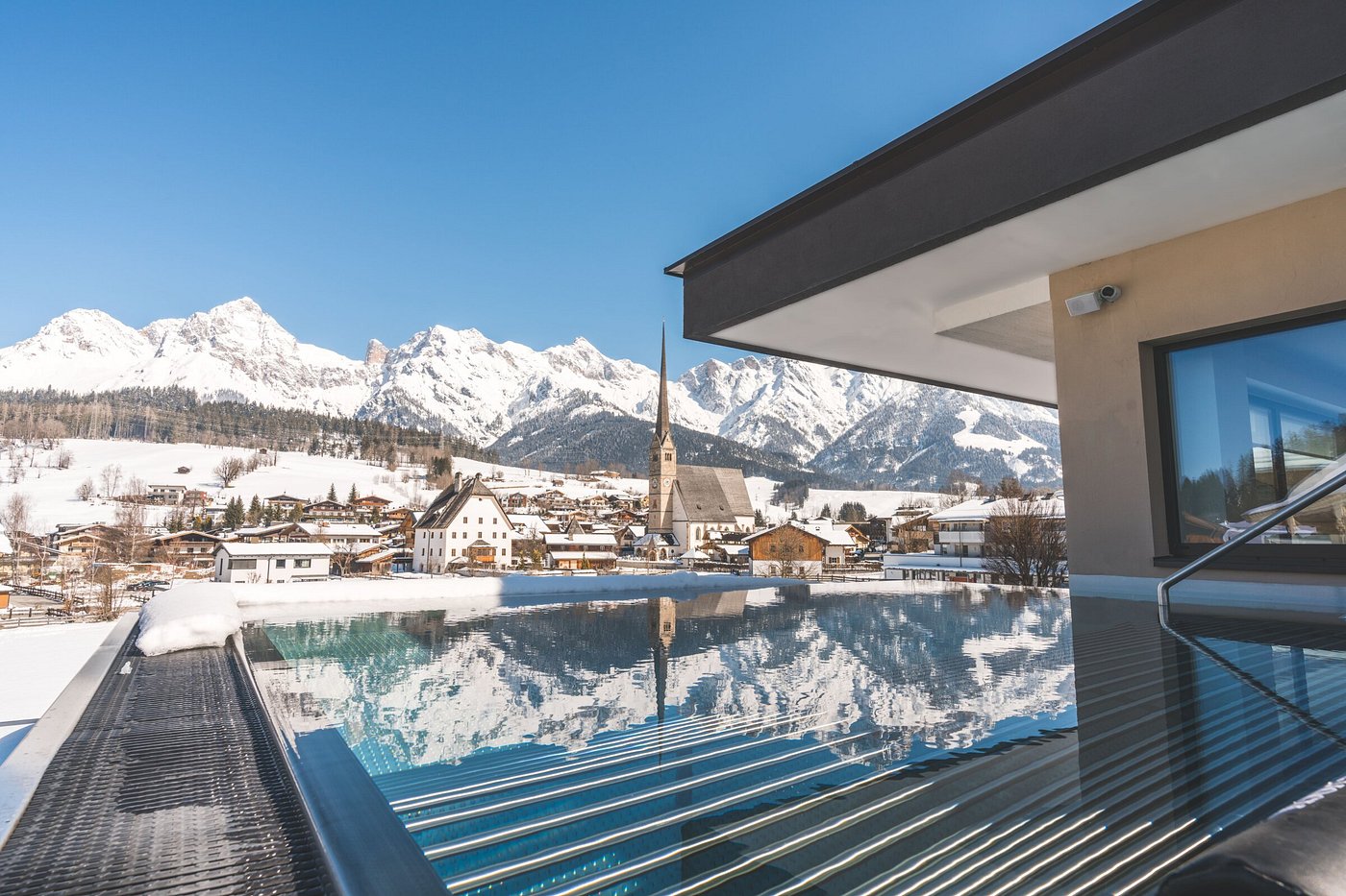 Ski resort at Hochkonigin in Hochkönig, Maria Alm, Austria featuring a chalet amidst stunning winter scenery with ski slopes, part of a winter sports centre.