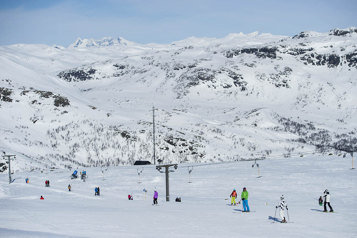 Tyin-Filefjell in Norway - a group of people skiing down a snowy mountain.