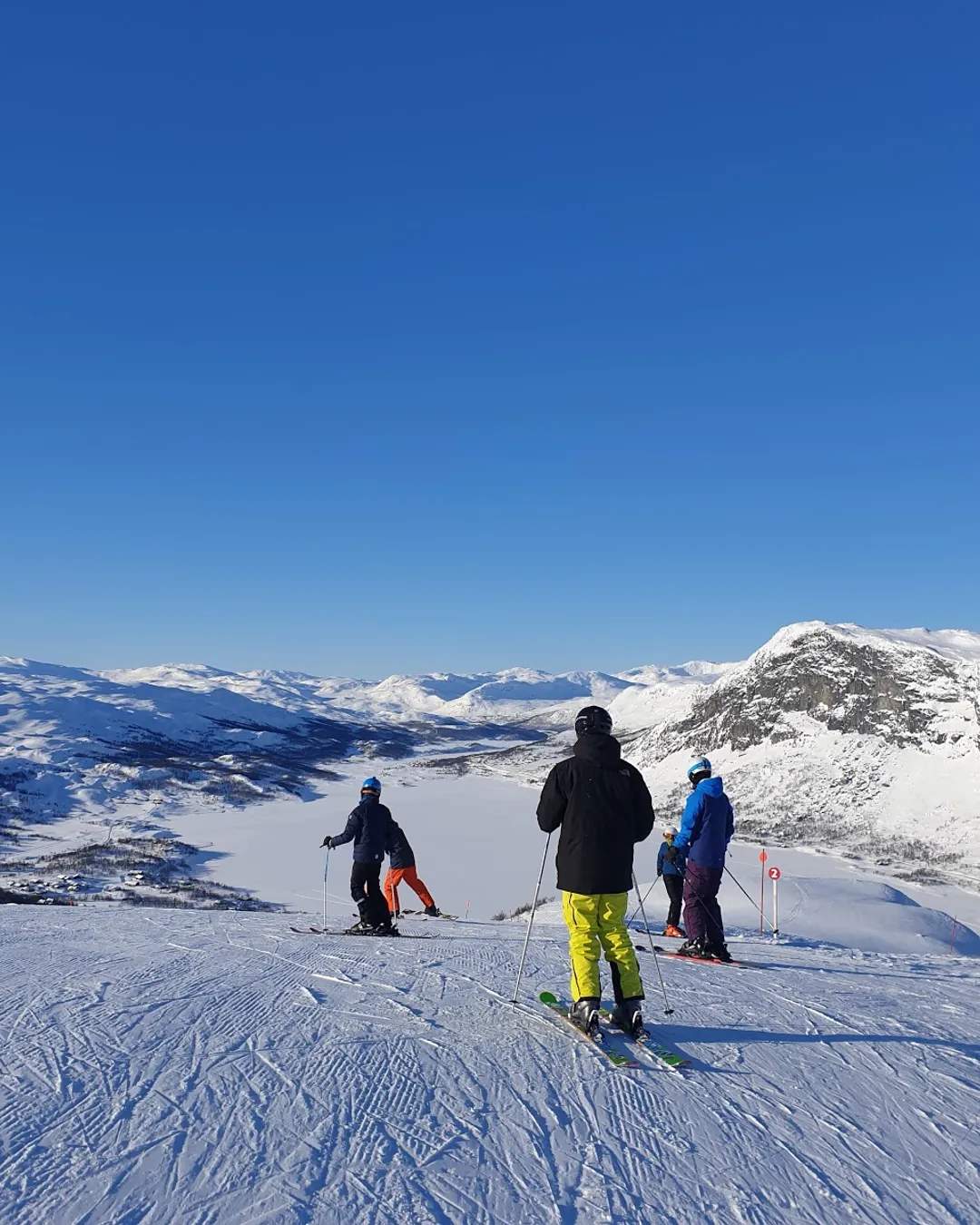 Tyin-Filefjell in Norway - a group of people skiing down a snowy slope.