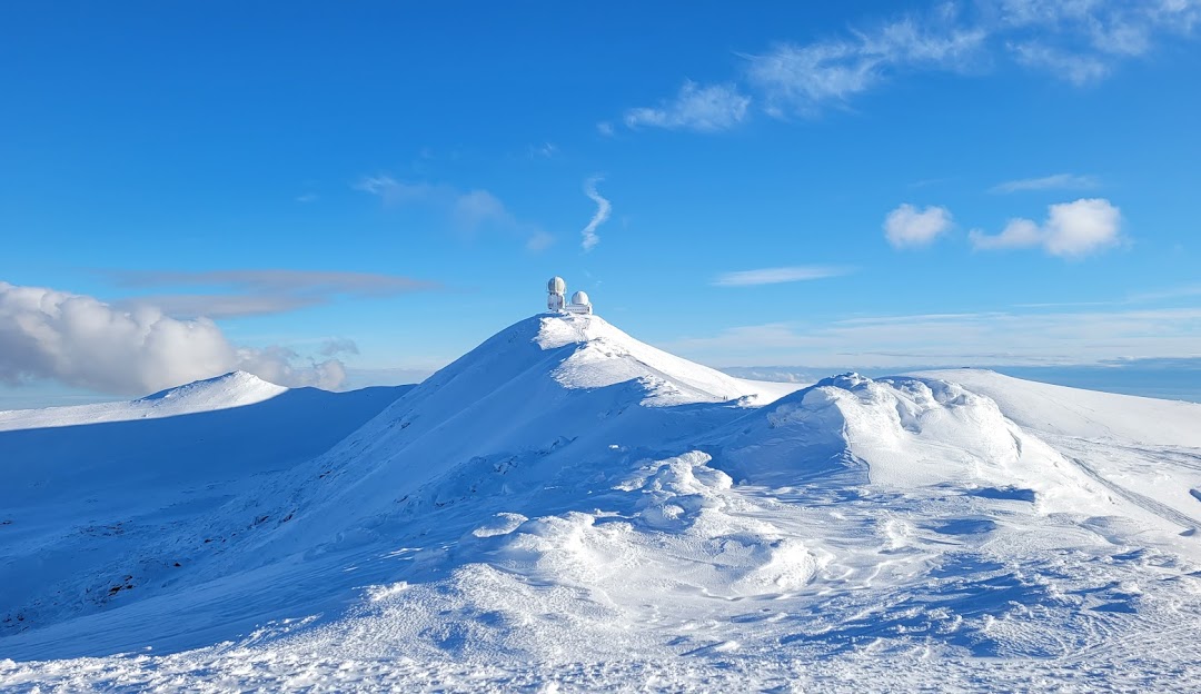 View of Koralpe in Lower Carinthia, Austria showcasing a snowy mountain peak, with a skier dotting the winter landscape, embracing the winter sports scene.