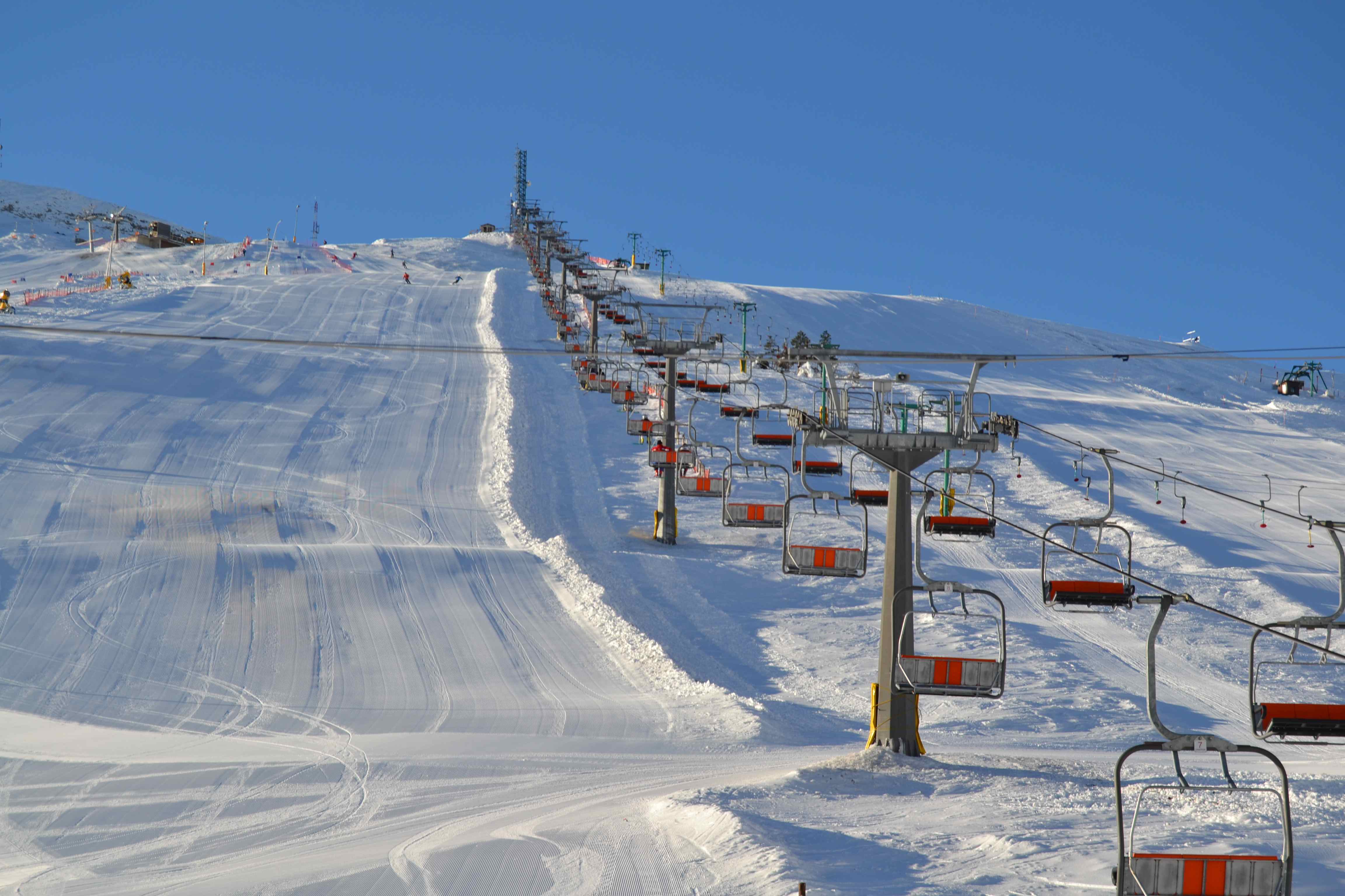 Winter sports scene at Risalita sciistica Carpegna - Eremo in Italy, featuring a ski lift and a ski resort, with a challet visible in the background.