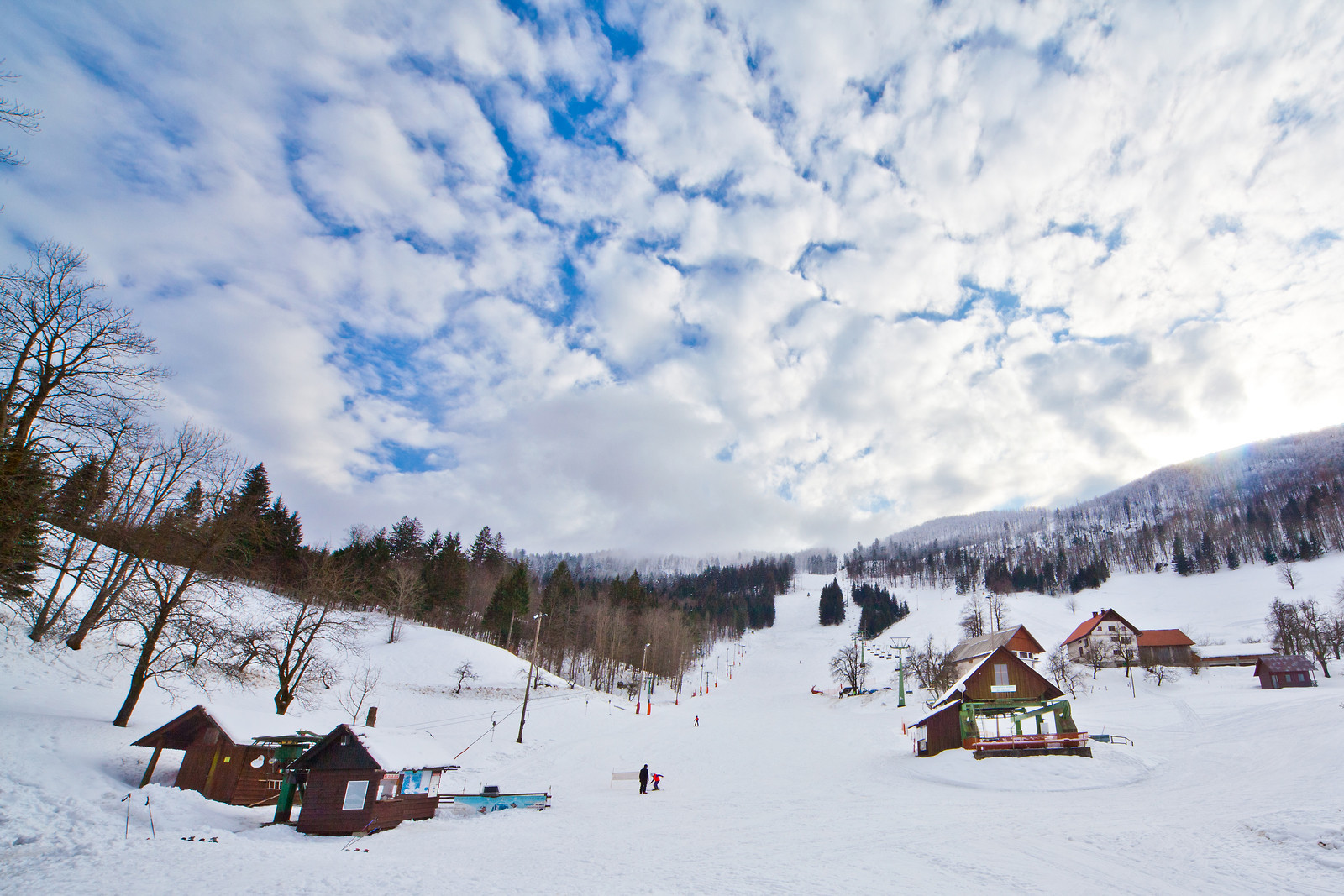 Javornik in Slovenia - a group of people skiing down a snowy hill.