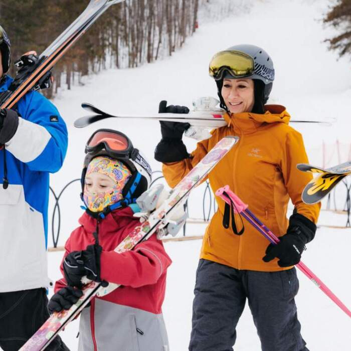 A lively family enjoying a day of skiing at the Horseshoe Resort in Barrie, Ontario, complete with children learning the ropes of winter sports.