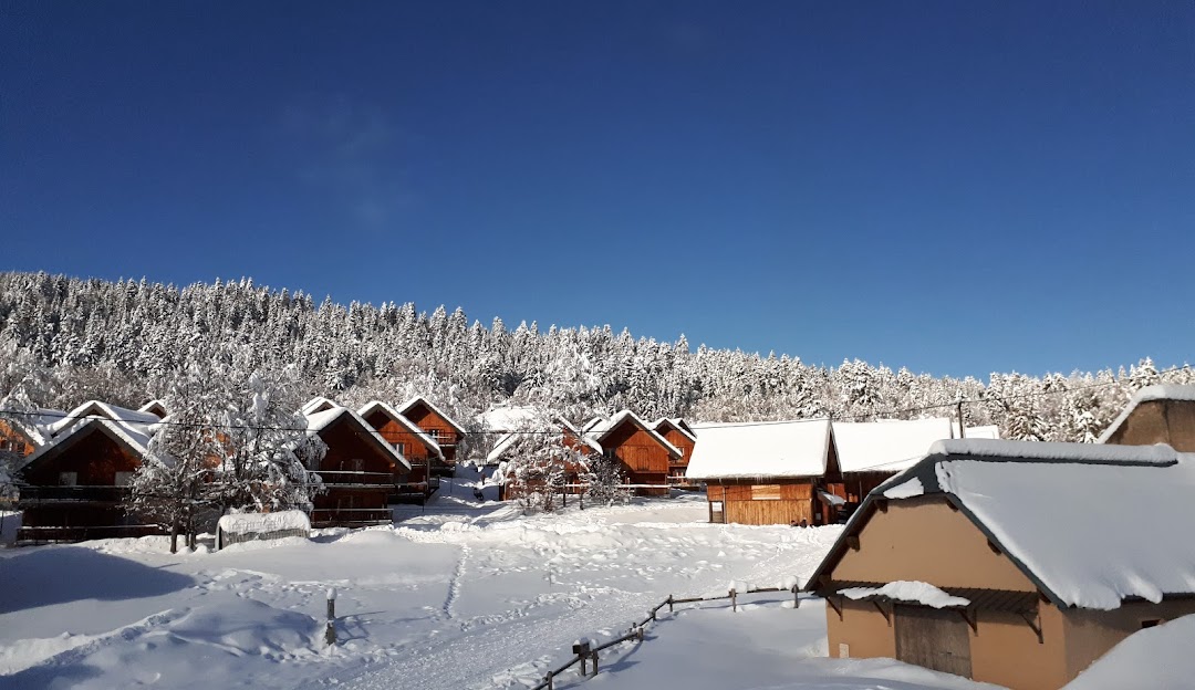 Winter scene at Savoie Grand Revard in France, featuring a bustling winter sports centre and ski resort against a stunning, serene winter scenery.