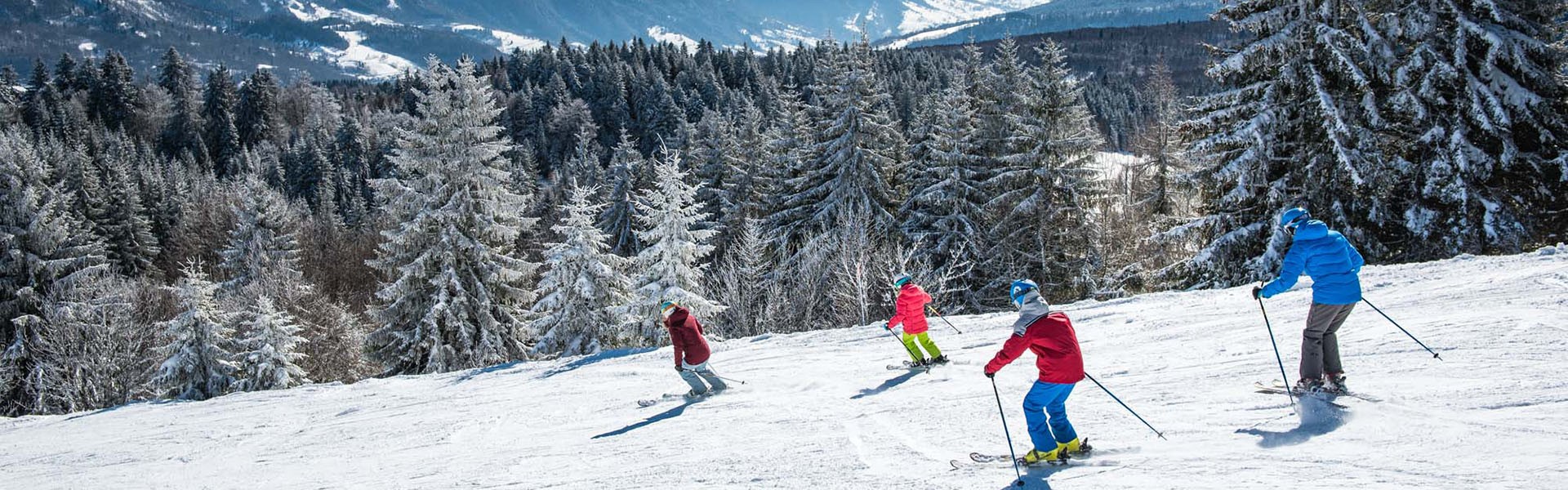 Winter sports scene at Savoie Grand Revard in France, featuring a bustling ski resort with a family and a group of people skiing, framed by a charming chalet amidst the snow-covered landscape.