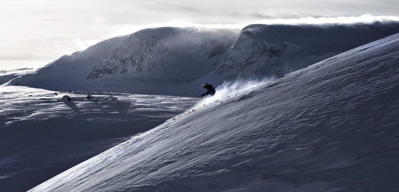 Hallingskarvet in Norway - a person is skiing down a snowy mountain.