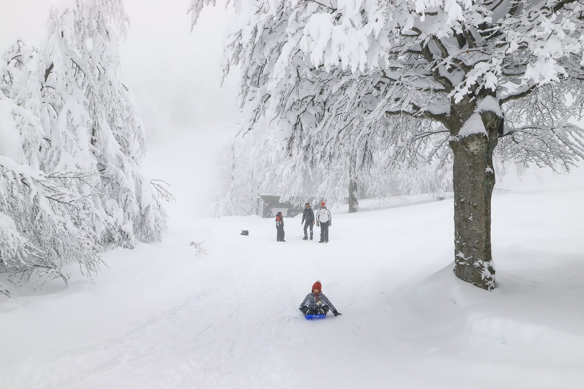 Winter sports scene at Passo dei Due Santi in Zum Zeri, Italy, featuring a sports centre and chalet set against a picturesque winter backdrop.