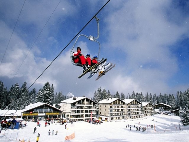Winter sports enthusiasts enjoy a lovely day at Mörlialp in Obwalden, Switzerland, taking a ski lift up to the resort for a day of skiing.