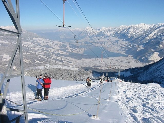 A vibrant winter scene at the Mörlialp ski resort in central Switzerland featuring a ski lift skiers enjoying the slopes and beautiful snowy surroundings.