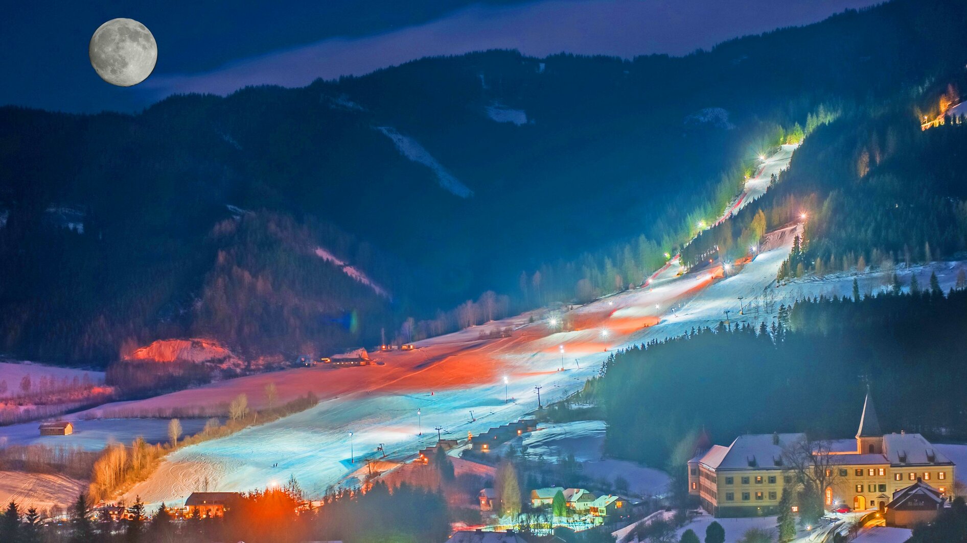Gaaler Lifte in Austria: a ski resort at night with the moon in the sky.