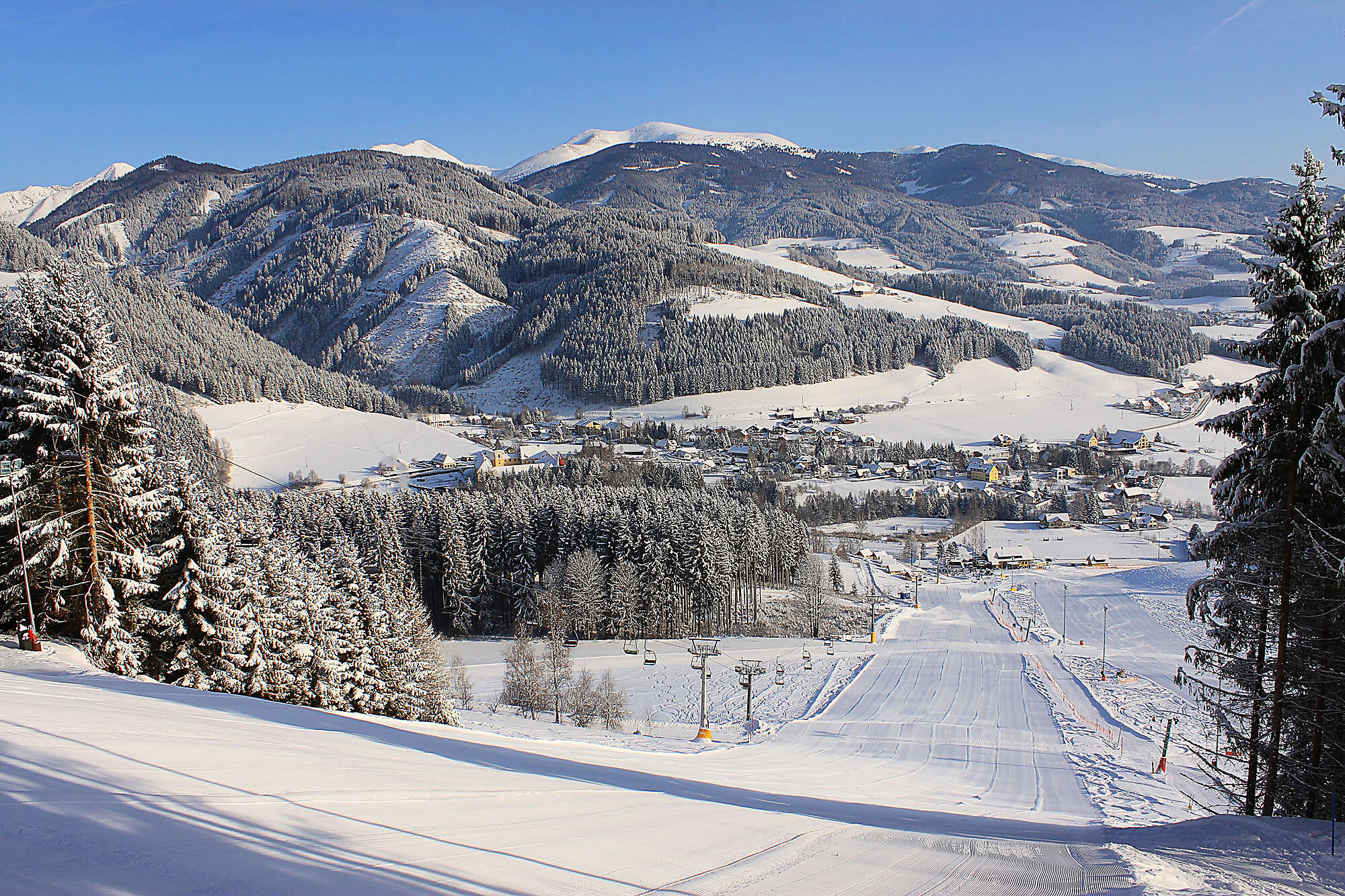Ski resort at Gaaler Lifte, Murtal, Gaal, Styria, Austria featuring a charming chalet, winter sports activities, and breathtaking winter scenery.