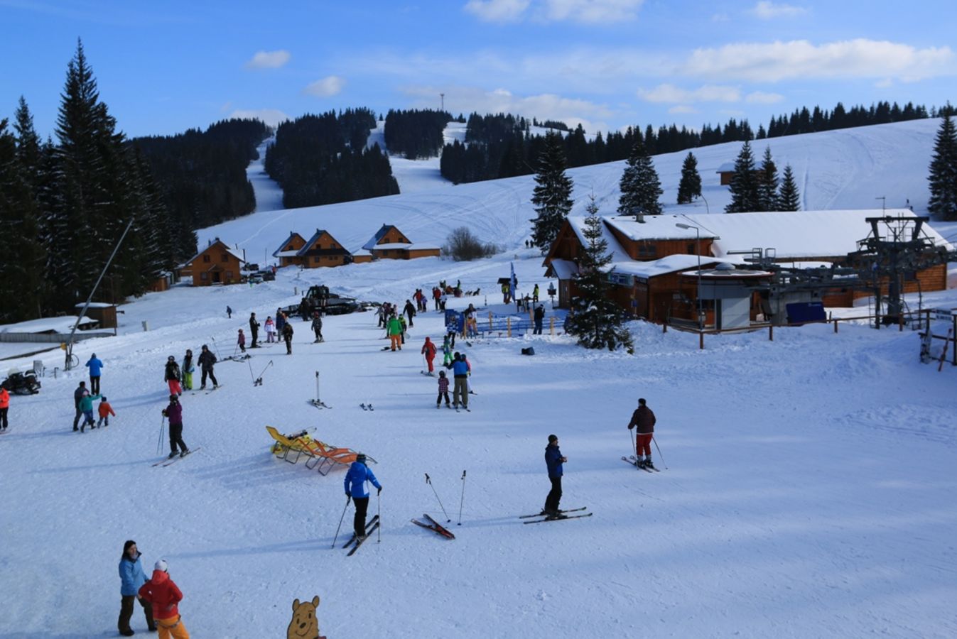 Orava Snow in Slovakia - a group of people skiing down a snowy hill.