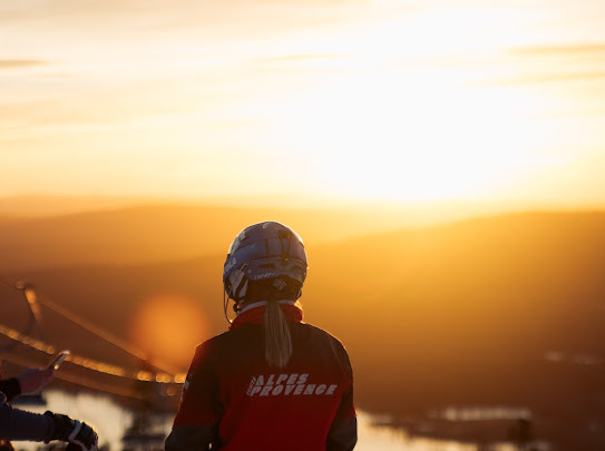 A skier carving through the snow on a sunny day in Kåbdalis, Northern Sweden. A mountain bike and charming challet are also visible in this winter sports scene.
