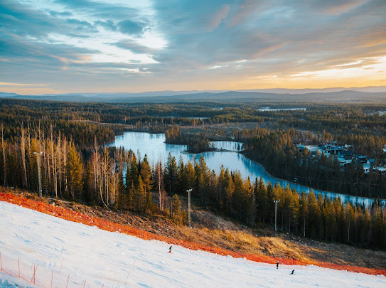 Winter sports scene at Kåbdalis in Norrbotten, Northern Sweden featuring a bustling ski resort set amidst stunning winter scenery with a ski lift ascending the snow-covered slopes.