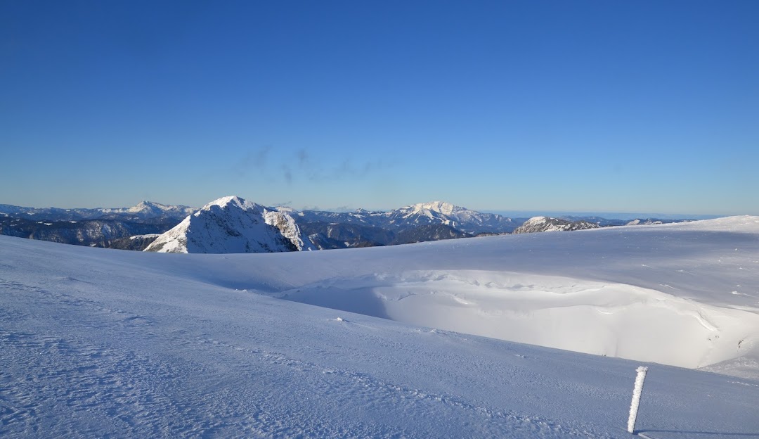 Winter sports scene at Brunnalm - Hohe Veitsch in Styria, Austria featuring a challet, ski resort and a vast snowy mountain landscape.