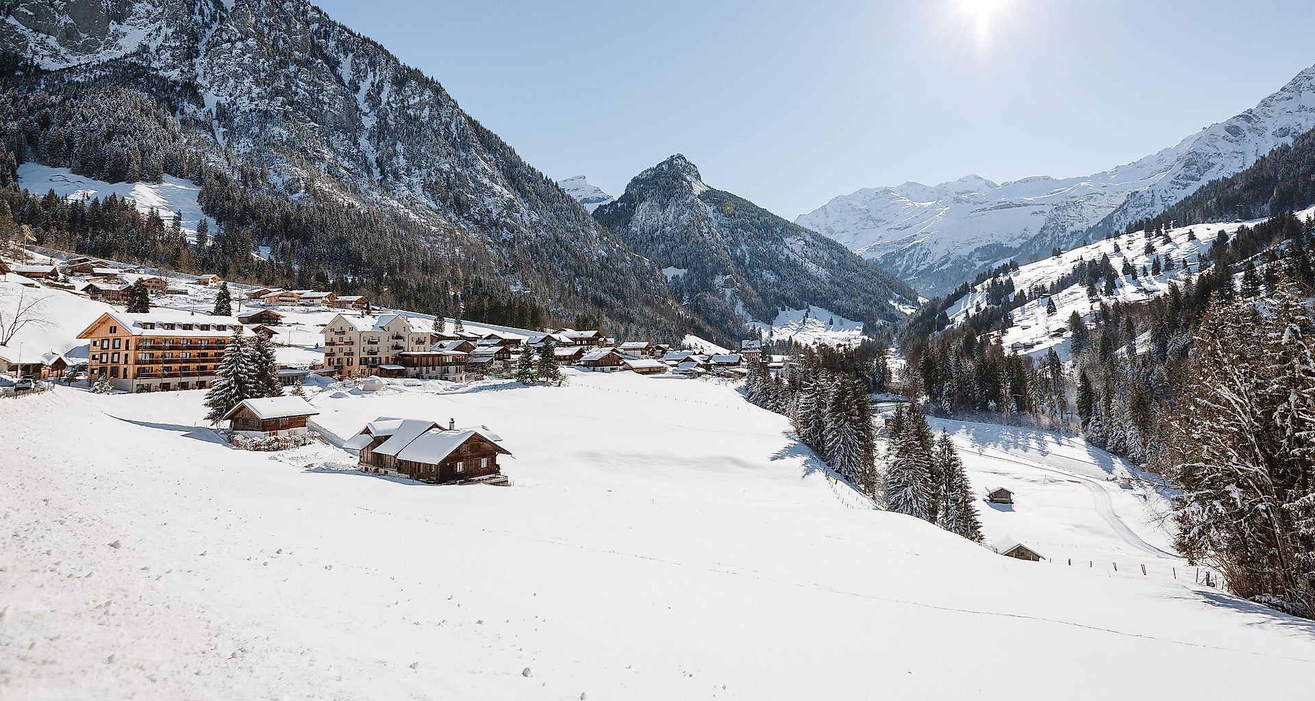 A lively winter sports scene unfolds at the ski resort in Kiental, Bernese Oberland, Switzerland. The picturesque winter scenery showcases a bustling winter sports centre amidst stunning natural beauty.