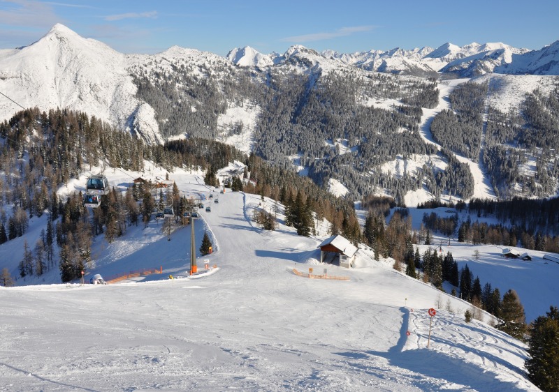 Ski resort at Zauchensee, Flachauwinkl, Austria, featuring a lively winter sports scene, a cozy chalet, amidst a stunning winter landscape.