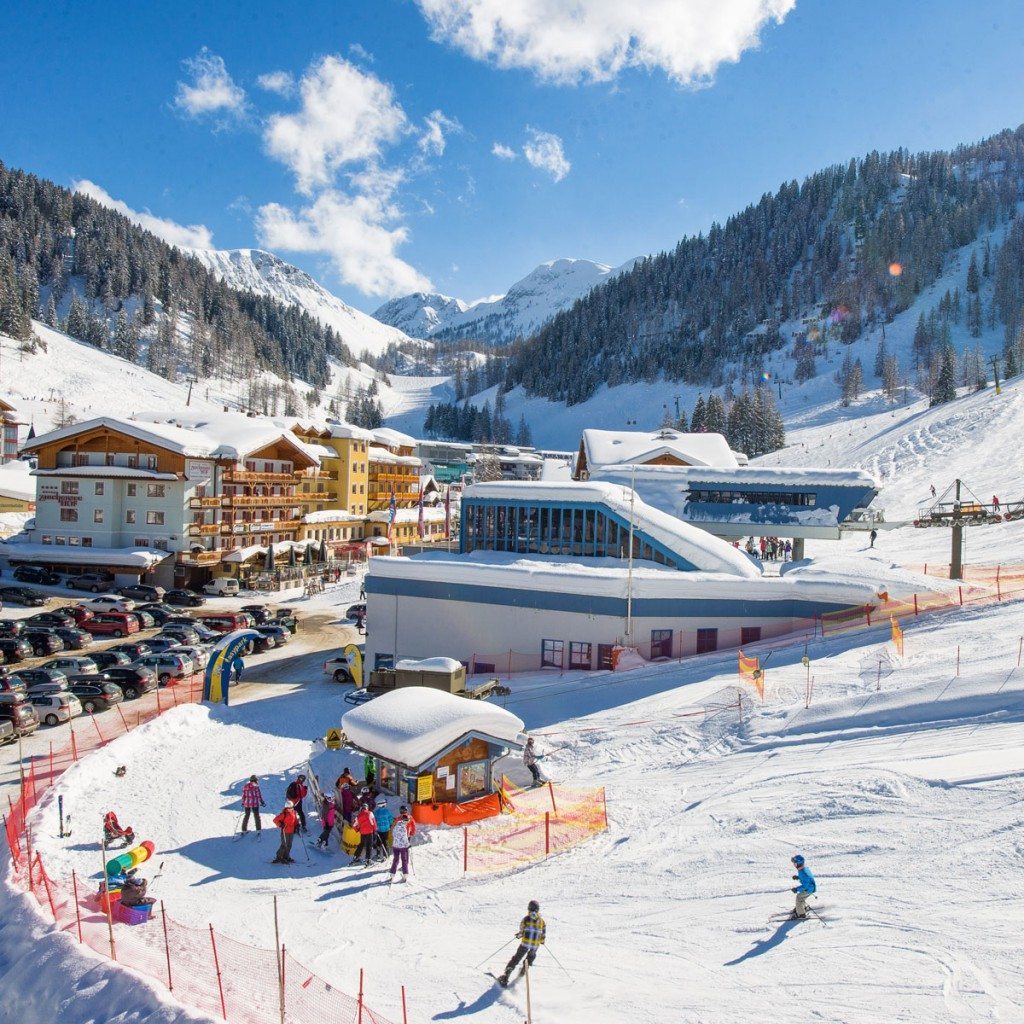 Zauchensee | Flachauwinkl in Austria: a ski resort with people skiing on the slopes.