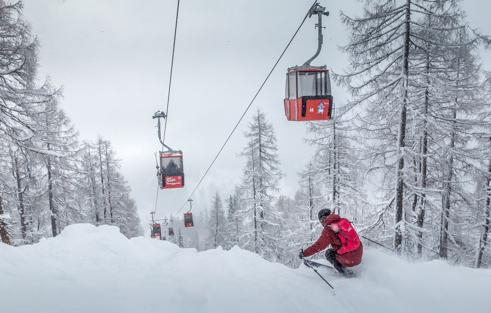 Zauchensee | Flachauwinkl in Austria - a person riding a ski lift in the snow.