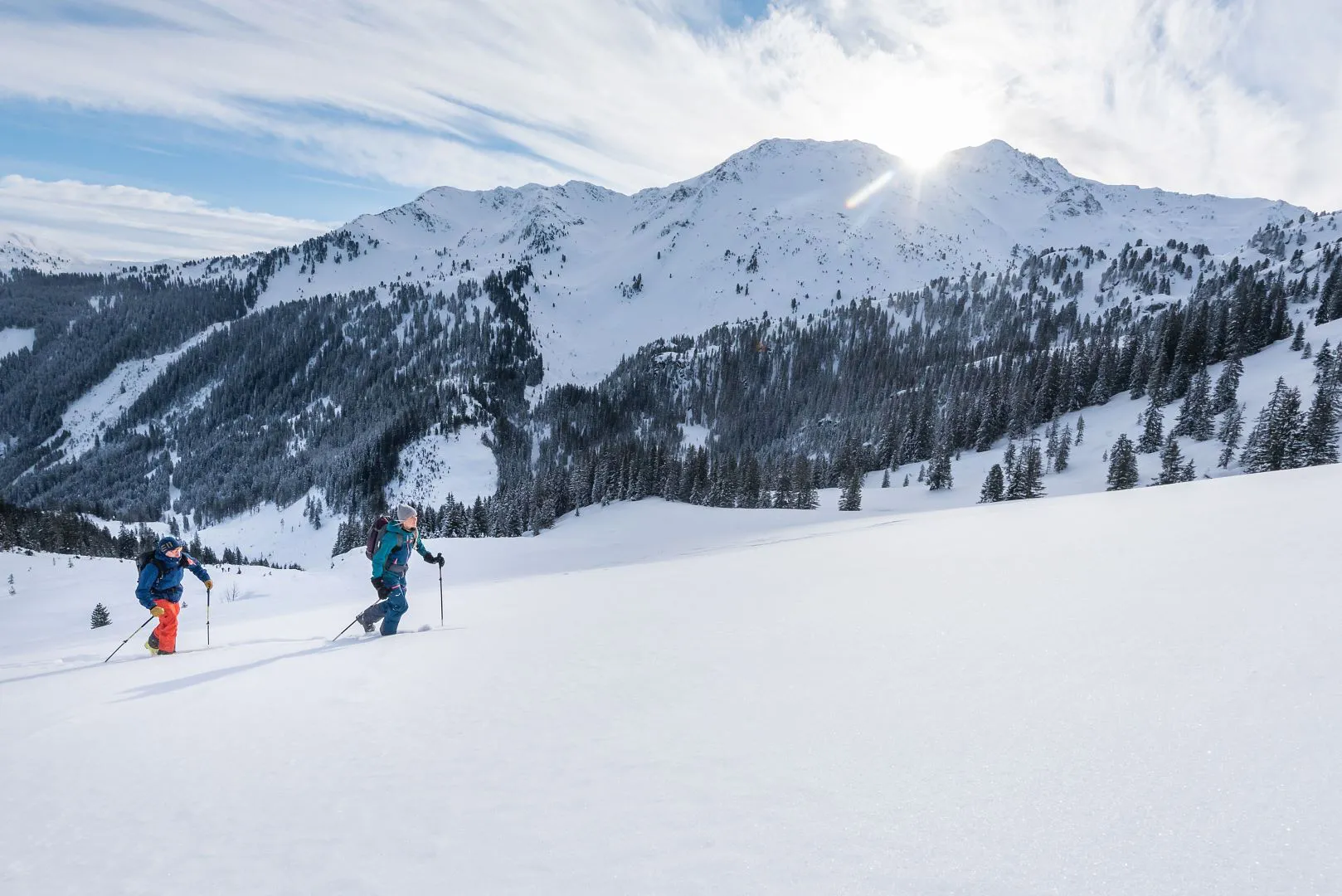 Kelchsau in Austria - two people skiing down a snow covered mountain.