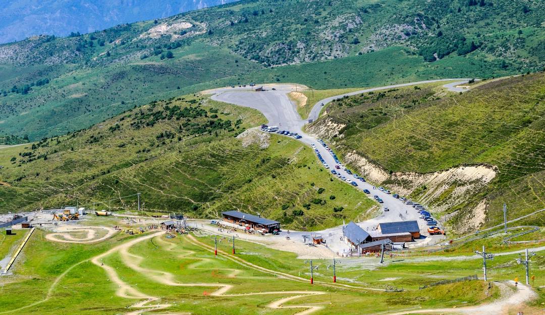 A picturesque view of the Hautacam ski resort in Haut-Pyrénées France. Snow dusted chalets dot the landscape with ski lifts visible in the distance creating a vibrant winter sports scene.