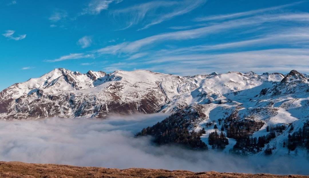 A breathtaking winter scene in Hautacam, France, featuring a stunning mountain view, a lively winter sports scene and a cozy chalet nestled amid the snow-covered landscape.